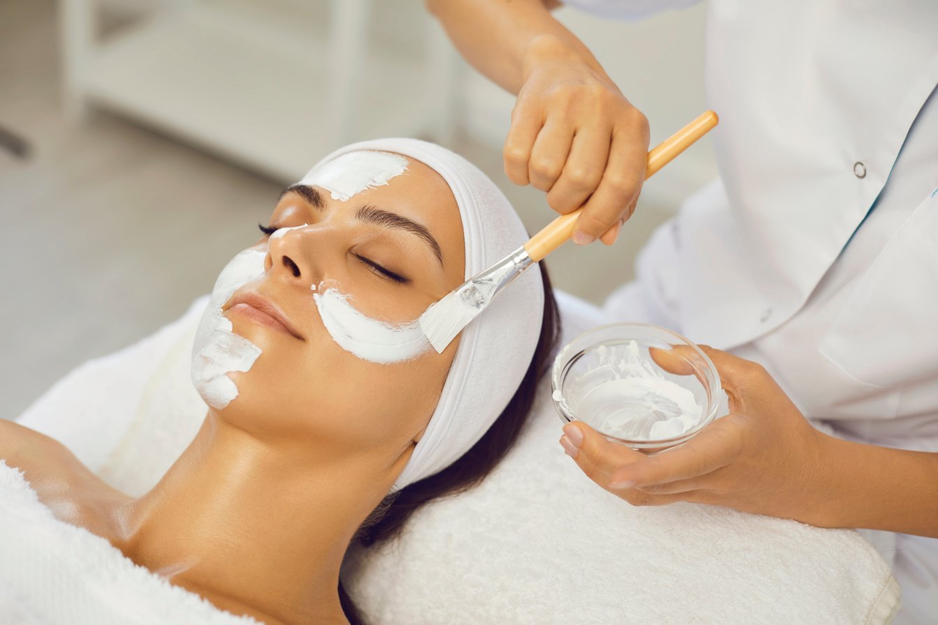 Cosmetologist Smearing Mask for Serene Woman in Beauty Spa Salon